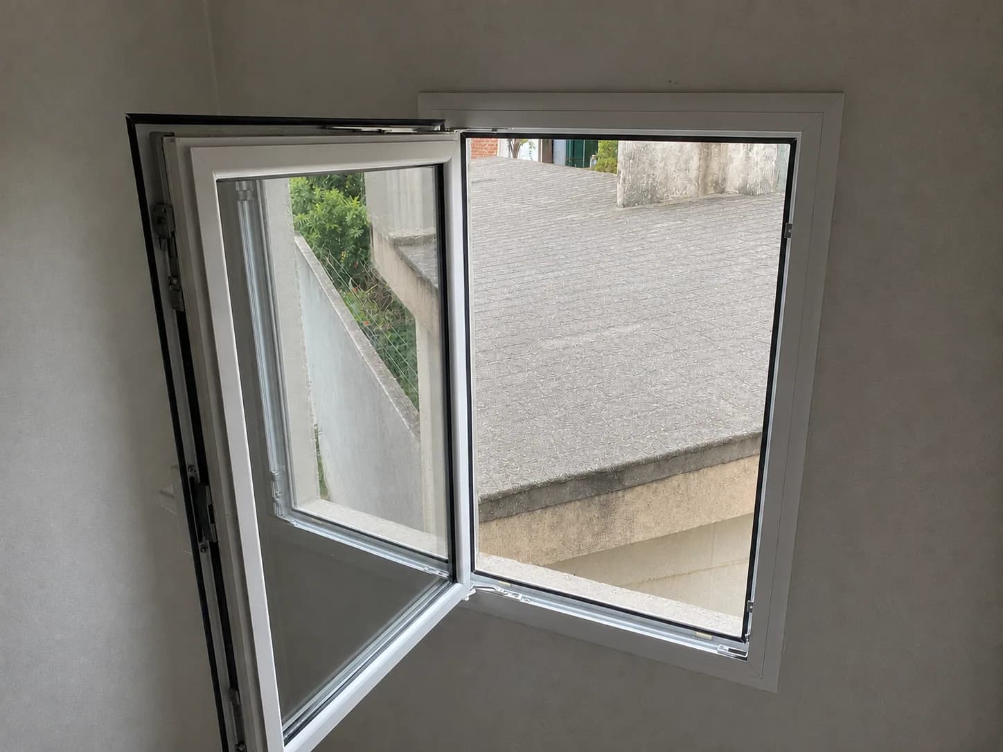 Ventana de dos hojas de aluminio blanco con una hoja abierta